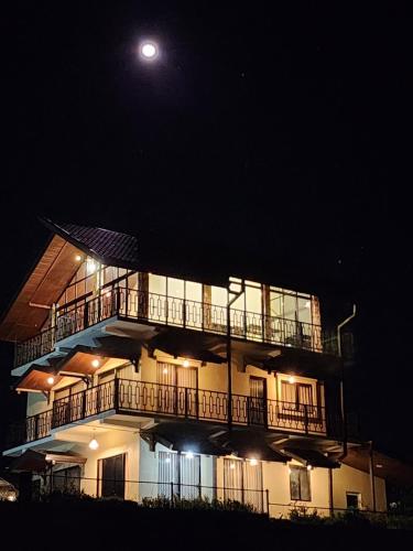 努沃勒埃利耶Villa Crosswinds Nuwara Eliya的天空中月亮的夜晚建筑