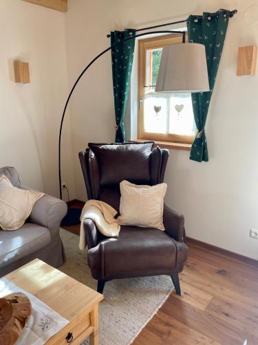 a living room with a leather chair and a lamp at Chalet Schäftal in Langau
