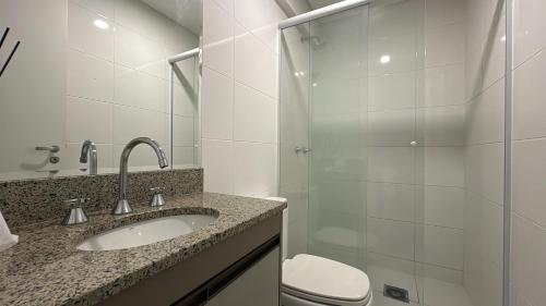 a bathroom with a sink and a toilet and a shower at Studio Batel com ótima localização in Curitiba