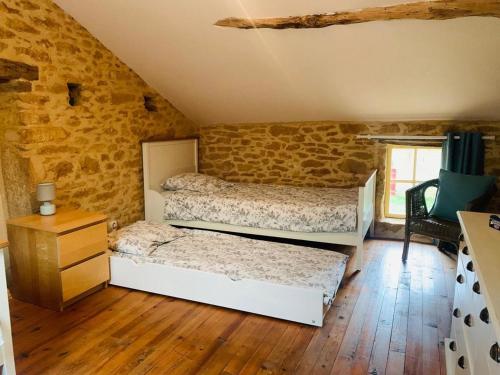 - une chambre avec 2 lits dans un mur en briques dans l'établissement Gite de la Renardière, à Paunat