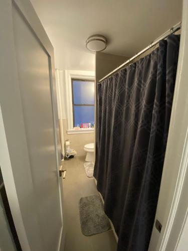 a bathroom with a toilet and a shower curtain at Large 3 bedroom perfect for families in New York