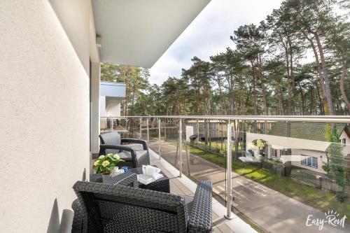 a balcony with chairs and a table on a balcony at Grunwaldzka 12 B22 - Easy-Rent Apartments - 50m od plaży in Pobierowo