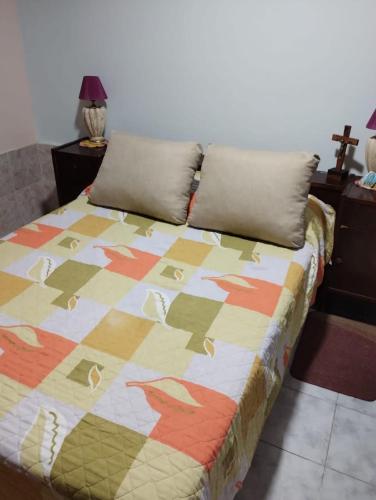 una cama con una colcha colorida en una habitación en Alquiler temporario amueblado en Junín