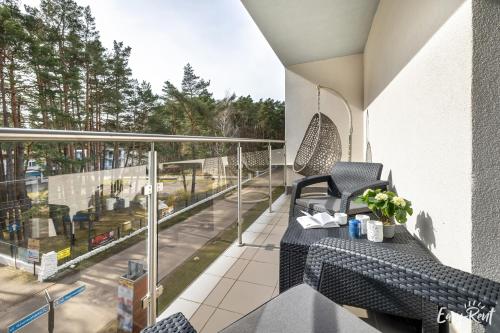 a balcony with a swing and a table on a balcony at Grunwaldzka 12 B22 - Easy-Rent Apartments - 50m od plaży in Pobierowo
