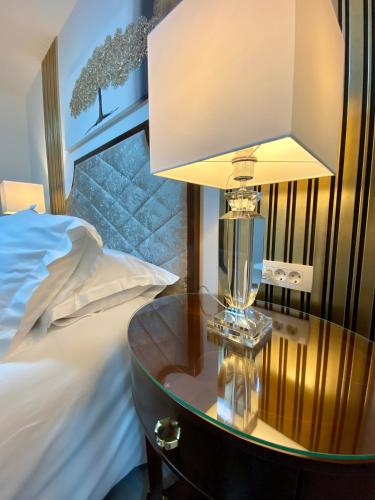 a lamp on a table next to a bed at Guesthouse Villa Vice in Split
