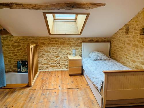 a bedroom with a bed and a skylight at Gite de la Renardière in Paunat