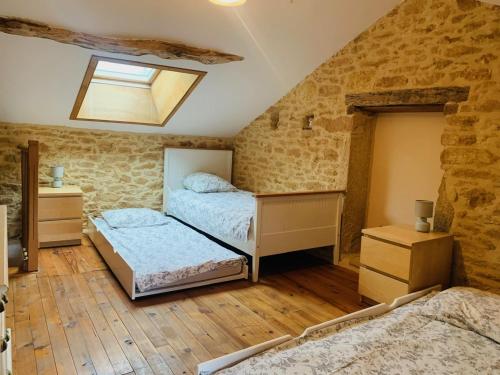 a attic bedroom with two beds and a skylight at Gite de la Renardière in Paunat