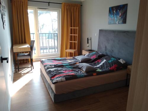 a bed in a room with a window at Na Wydmach u Iwony in Międzywodzie
