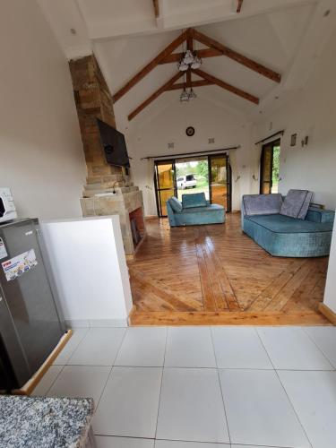 sala de estar con 2 sofás azules y suelo de madera en Kichaka Cottages, en Nyeri