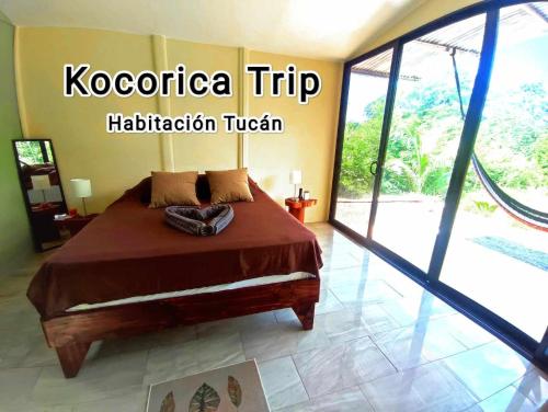 a bedroom with a bed and a sliding glass door at Kocorica in Parrita