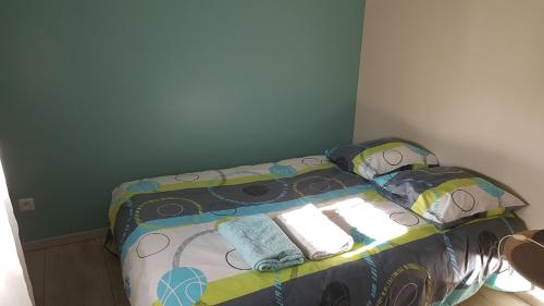 - un petit lit dans une chambre dotée d'un couvre-lit et d'oreillers dans l'établissement Maison entière, à Cérans-Foulletourte