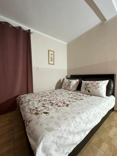 sypialnia z dużym łóżkiem z kwiatami w obiekcie Apartmani Simona w Budvie
