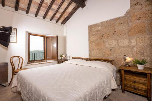 Un dormitorio con una cama grande y una ventana en La Rocca - Palazzo Pallotti, en Lubriano