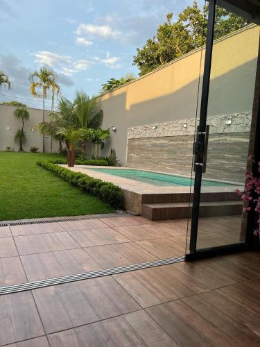 uma vista para uma piscina a partir do exterior de uma casa em Casa Sa Pedra em Aparecida de Goiânia