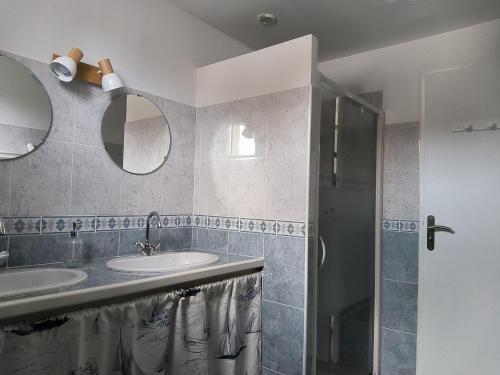 een badkamer met 2 wastafels en een douche bij La noix qui roule in Champagnac-de-Bélair