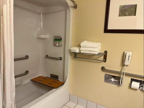 a bathroom with a shower and a toilet and a phone at The Arc Hotel in Fort Smith