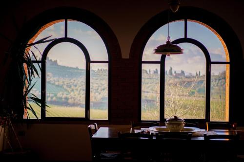 a room with three arched windows and a table with a bowl on it at Casa Caterina in Moncioni
