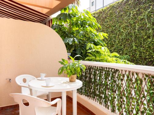 una mesa blanca y sillas en un balcón con plantas en Live Garachico Humbolt, en Caleta de Interián