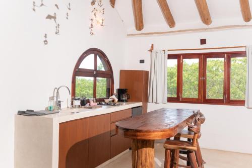 a kitchen with a wooden table and a sink at Casa Takywara in Holbox Island