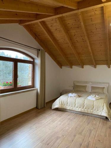 a bedroom with a bed and a large window at Bujtina Salko in Muçaj