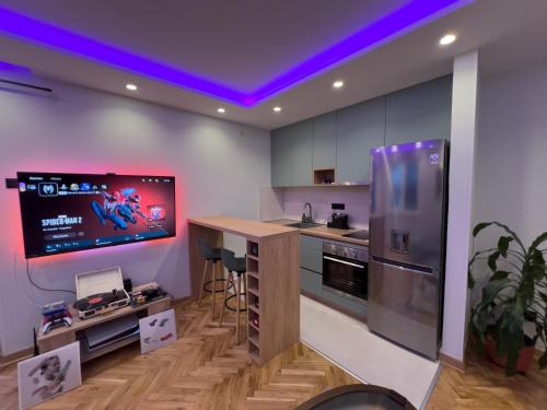een keuken met een tv aan de muur en een aanrecht bij City Gem: Stylish Urban Hideout in Budva
