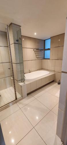 a large bathroom with a tub and a shower at SUPER MARES_Comfortable & Cozy Apartment in Maputo
