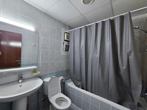 La salle de bains est pourvue de toilettes, d'un lavabo et d'une douche. dans l'établissement ZLEEP, à Ajman