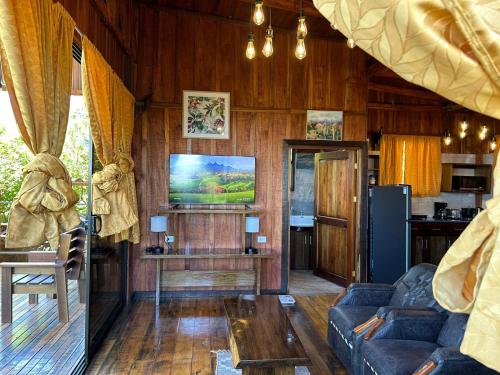 a living room with a couch and a tv at Casa Torre Eco- Lodge in Fortuna