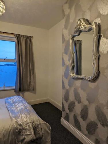 1 dormitorio con espejo, cama y ventana en Cozy flat en Newport
