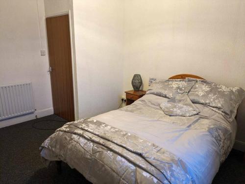 een slaapkamer met een bed en een houten hoofdeinde bij Cozy flat in Newport