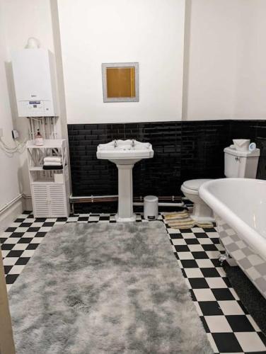 a bathroom with a sink and a tub and a toilet at Cozy flat in Newport