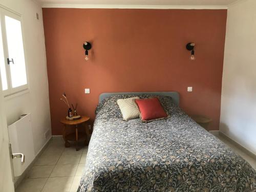 - une chambre dotée d'un lit avec un mur rouge dans l'établissement Casa Salies, maisonnette cosy et confortable au centre de Salies, à Salies-de-Béarn
