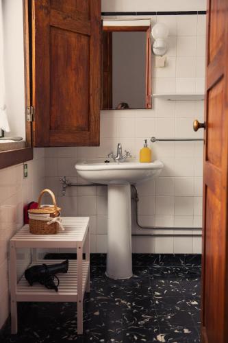 a bathroom with a sink and a table with a basket at Quinta da Travessa - Douro in Covelinhas