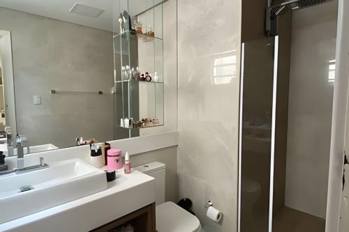 a bathroom with a sink and a toilet and a mirror at Ampla casa com piscina na Pituba in Salvador