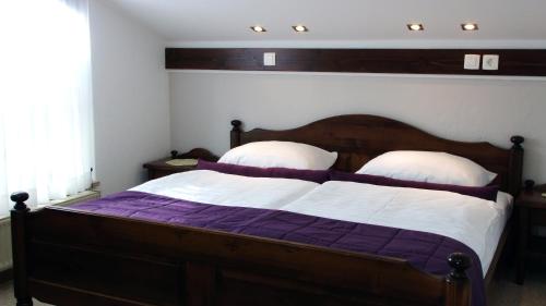 1 dormitorio con 1 cama de madera y 2 almohadas en Apartment MaLa, en Bled