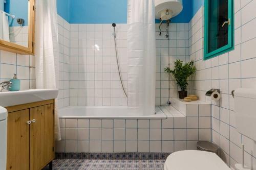 a bathroom with a tub and a toilet and a sink at Cosy Apartment In Party District K30 in Budapest