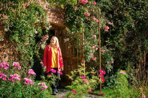 a man and a girl standing in a garden at Courtyard Cottages at Ballyscullion Park in Derry Londonderry