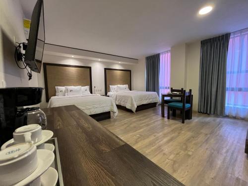 una habitación de hotel con 2 camas y una mesa con platos en Hotel Lepanto Reforma, en Ciudad de México