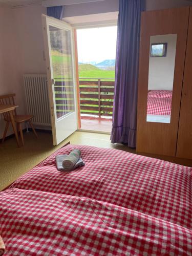 a bedroom with a bed with a red and white checkered blanket at Plasur - Apartement Bella Vista in Montechiaro
