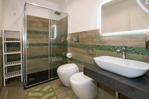 a bathroom with a sink and a shower and a toilet at Villa del Papiro Charme Apartments in Avola