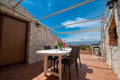 a table and chairs on a patio with a view of the ocean at Villa del Papiro Charme Apartments in Avola