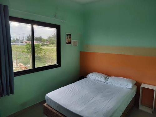 een bed in een kamer met een raam en een bed sidx sidx sidx bij Casa a 550m da praia e 350m da Lagoa da Tapera. in Passo de Torres