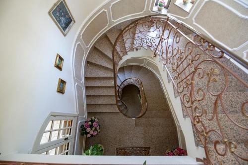 a spiral staircase in a house with flowers at Villa del Papiro Charme Apartments in Avola