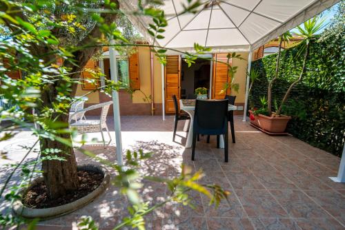 a patio with a table and chairs under a tent at Villa del Papiro Charme Apartments in Avola
