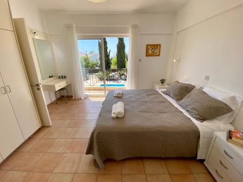 a bedroom with a bed and a view of a pool at Villa Lorena Protaras in Protaras