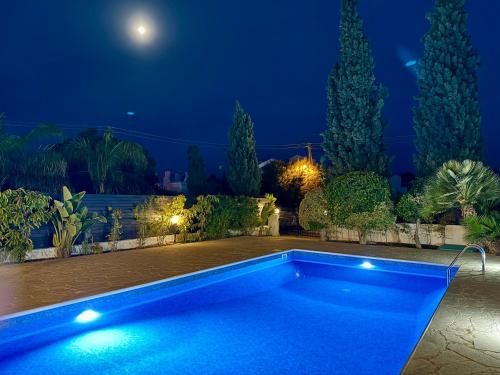 a swimming pool in a yard at night at Villa Lorena Protaras in Protaras
