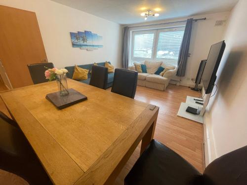 a living room with a dining room table and a couch at Spacious Apartment near Heathrow with Allocated Parking in Uxbridge