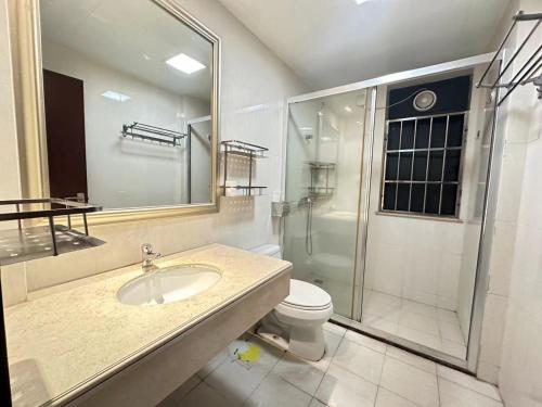 a bathroom with a toilet and a sink and a shower at Guangzhou Phantom Oasis Apartments - Canton Fair Exhibition Area in Guangzhou
