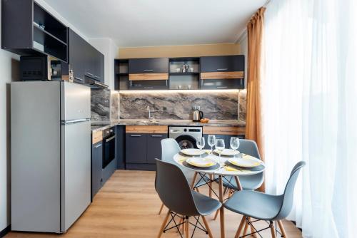 una cucina con tavolo, sedie e frigorifero di Best Guest 2 Apartments a Plovdiv