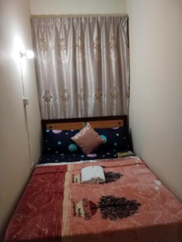 a small bed in a small room with a curtain at My Home Stay apartment 2 in Abu Dhabi
